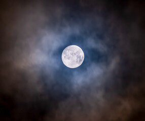 Naklejka na ściany i meble Glowing Illuminated full moon with dark clouds on this eerie night.