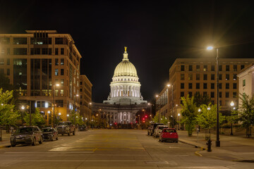 Illuminated Wisconsin State Capitol at night.  Street scene with a white dome.