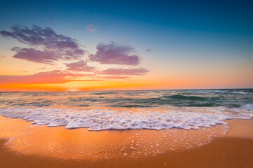 Naklejka na ściany i meble Beautiful sunrise over the sea sand and beach. Ocean beach.