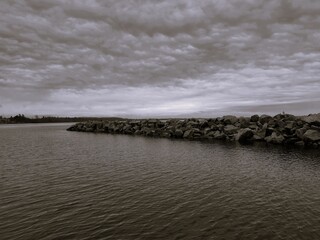 rocks in the sea under cloudy sky