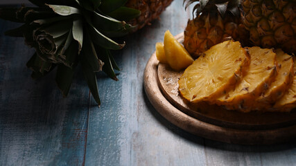 Close up fresh sliced pineapple on wooden background. Top view, tropical fruits, summer concept