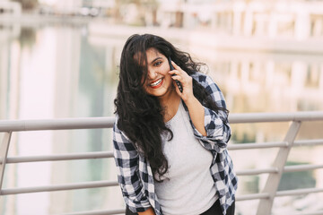 Portrait of a beautiful laughing Indian woman talking on the phone