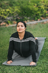 A beautiful Indian girl does yoga in a summer park. Healthy lifestyle. Various yoga poses.