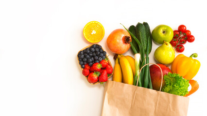 Paper bag with fruits and vegetables lies on a white background