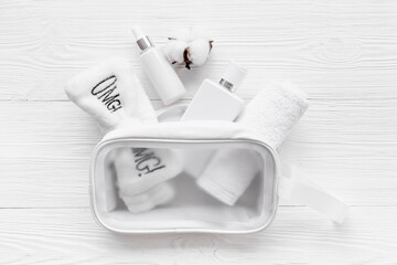 Fototapeta na wymiar Set of cosmetic bag with white makeup bottles and tubes, top view