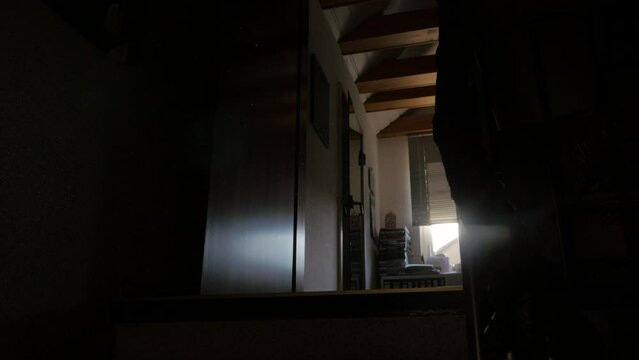Dark wooden house interior with sunlight creeping through window.