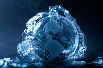 Symbol photo World in plastic. Globe wrapped with plastic film.