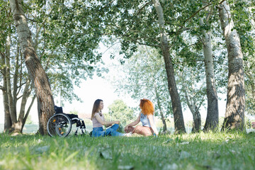 A woman with a disability and her female friend having a conversation in a shade of beautiful...