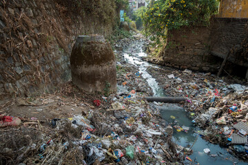 A sewer full of plastic and toxic waste flowing in open. Dehradun, uttarakhand India. - obrazy, fototapety, plakaty