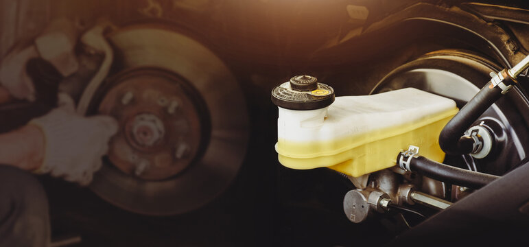 Brake fluid reservoir of car brake system with a disc brake repairing double exposure blurred on background