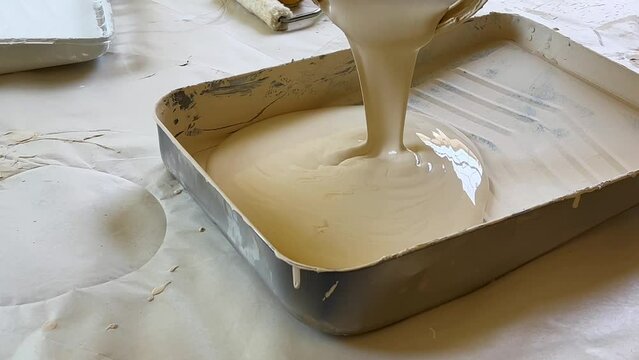 Pouring A Can of Ivory White Paint into an Aluminum Pan, Satisfying Pouring of Fresh Paint into Tray