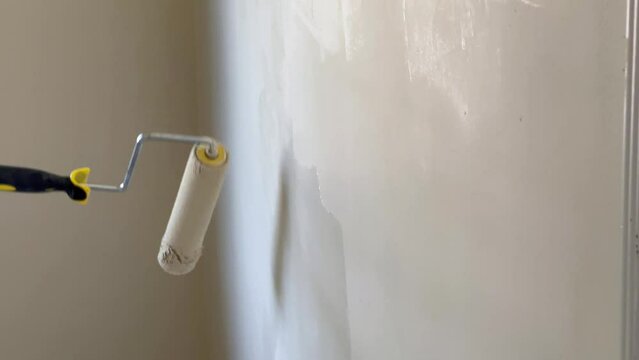 Rolling Paint Brush Rolls Across Wall, Painter uses painter's pole to Refresh Room Aesthetic
