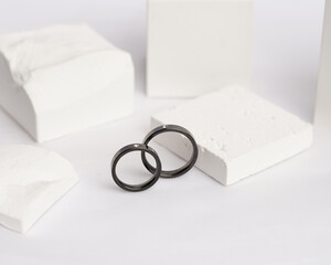 Diamond jewelery ring for social media display. Wedding ring photographed on white stone. Engagement ring with gemstones. Wedding rings isolated on a bright white background, focus blur. Gold ring.