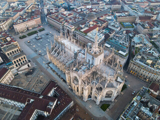 Naklejka premium Aerial view of Duomo di Milano Cathedral in Duomo Square. Gothic cathedral in the center of Milan. Drone view of the gallery and Milano rooftops, in north Italy, Lombardia. Birds eye of Duomo facade.