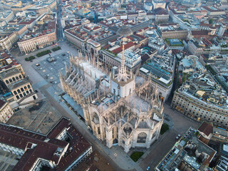 Aerial view of Duomo di Milano Cathedral in Duomo Square. Gothic cathedral in the center of Milan. Drone view of the gallery and Milano rooftops, in north Italy, Lombardia. Birds eye of Duomo facade. - obrazy, fototapety, plakaty