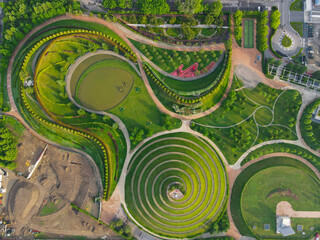 Aerial view of Parco del Portello in Milan, near CityLife, Lombardia. View from the height of park with a green lawn and paths. Abstract design similar to a dragon. Drone photography in Milano.