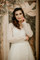 Beautiful bride posing in wedding dress in photo Studio. Beauty portrait of bride wearing fashion wedding dress with feathers with luxury delight make-up and hairstyle. Young attractive Kurdish model.