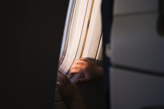 機内から外を眺める子ども
