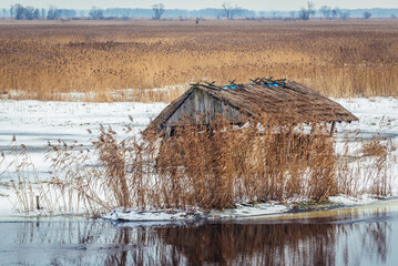 Hay rack on a frozen chanel of River Narew seen from a bank in Waniewo village, Podlasie region in...