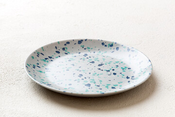 Perspective view of empty colorful plate on cement background. Empty space for your design
