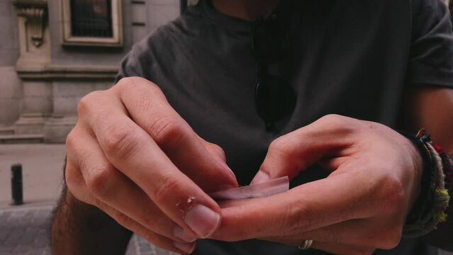 Slow-mo Rolling a tobacco cigarette in 4k. Close-up in slow motion of a cigarette being rolled. Man hands close-up. 4k 60fps in slow motion.