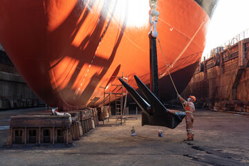 Workers working in a shipyard and painting in naval industry
