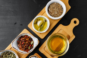 Oil, herbs and spices on wooden background