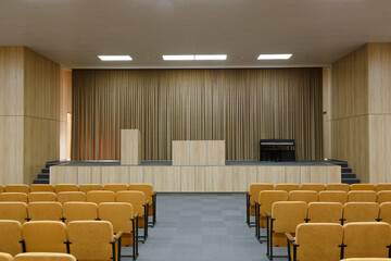 Assembly hall at the school with empty chairs and stage. Hall for a small audience to organize...