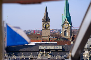 Aerial view over City of Zürich from ferris wheel with defocus flag of City and Canton Zürich in the foreground and focus on background. Photo taken March 28th, 2022, Zurich, Switzerland.
