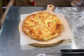 Freshly baked and sliced cheese pizza or casserole. Brown crust.