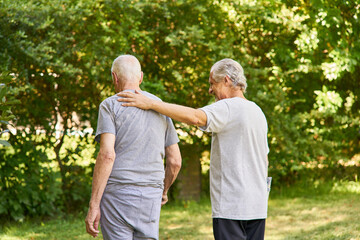 Mann tröstet Senior und hilft beim Gehen lernen