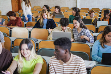 Young multiethnic students working with tablets inside classroom at school university - Focus on...