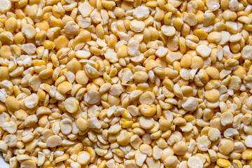 Yellow, dried peas scattered background. Food backdrop.