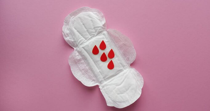 Women's sanitary napkins and drops of blood cut out of paper. Menstrual cycle. Looped 4K stop motion animation