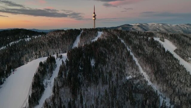 4K Aerial winter sunrise or sunset view of Rhodope Mountains and Snezhanka tower near resort of Pamporovo, Smolyan Region, Bulgaria