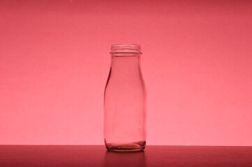 White glass bottle isolated on a red background