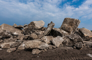 big pile of construction rubble of a demolished building under a blue sky
