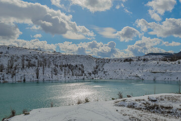 Panorama of the Martian turquoise lake in the Crimea with a view of the snow-covered slopes