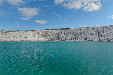 Martian turquoise lake in Crimea with a view of the snow-covered slopes