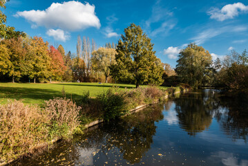  the banks of a creek in the King Baudouin city park during a sunny autumn day with colorful trees