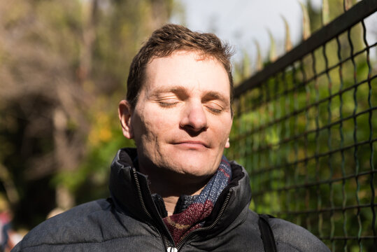 Portrait Of A Handsome Forty Year Old Man With Glasses And Winter Clothes, Eyes Closed