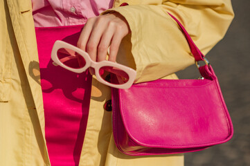 Close up trendy spring fashion outfit with pink, fuchsia color faux leather mini bag, sunglasses - obrazy, fototapety, plakaty
