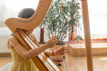 The child plays the harp. Selective focus.