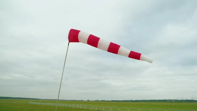Field Airfield. Determining Force and Direction of Wind. Small Aviation. Weather. Wind. Windy. Striped Indicator. Windsock. Overcast Weather. Field. Horizon. Clouds. Summer. Rarely visited Airfield