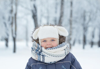 Fototapeta na wymiar little happy boy in snowy winter park