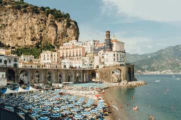 Panoramic view of Atrani, the city on the Amalfi coast, with beach, parasols, and people, enjoying...