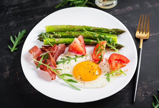 Fried egg with asparagus, tomato and bacon. Useful breakfast.