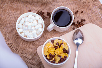 Light breakfast. Cereal with milk and coffee with marshmallows