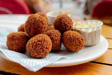 Bitterballen, Dutch meat-based snack in white plate served with mustard on wooden tabel background, Typically containing a mixture of beef or veal, Bitterballen are one of Holland's favorite snacks.