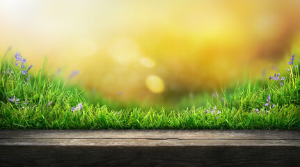 A wooden table product display with warm sunset summer garden background of green grass and blurred...